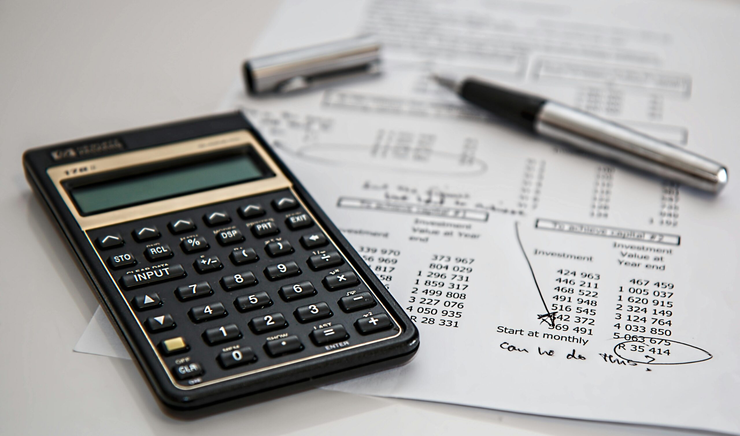 Close-up of financial documents with calculator and pen, ideal for business management themes. Creating a budget