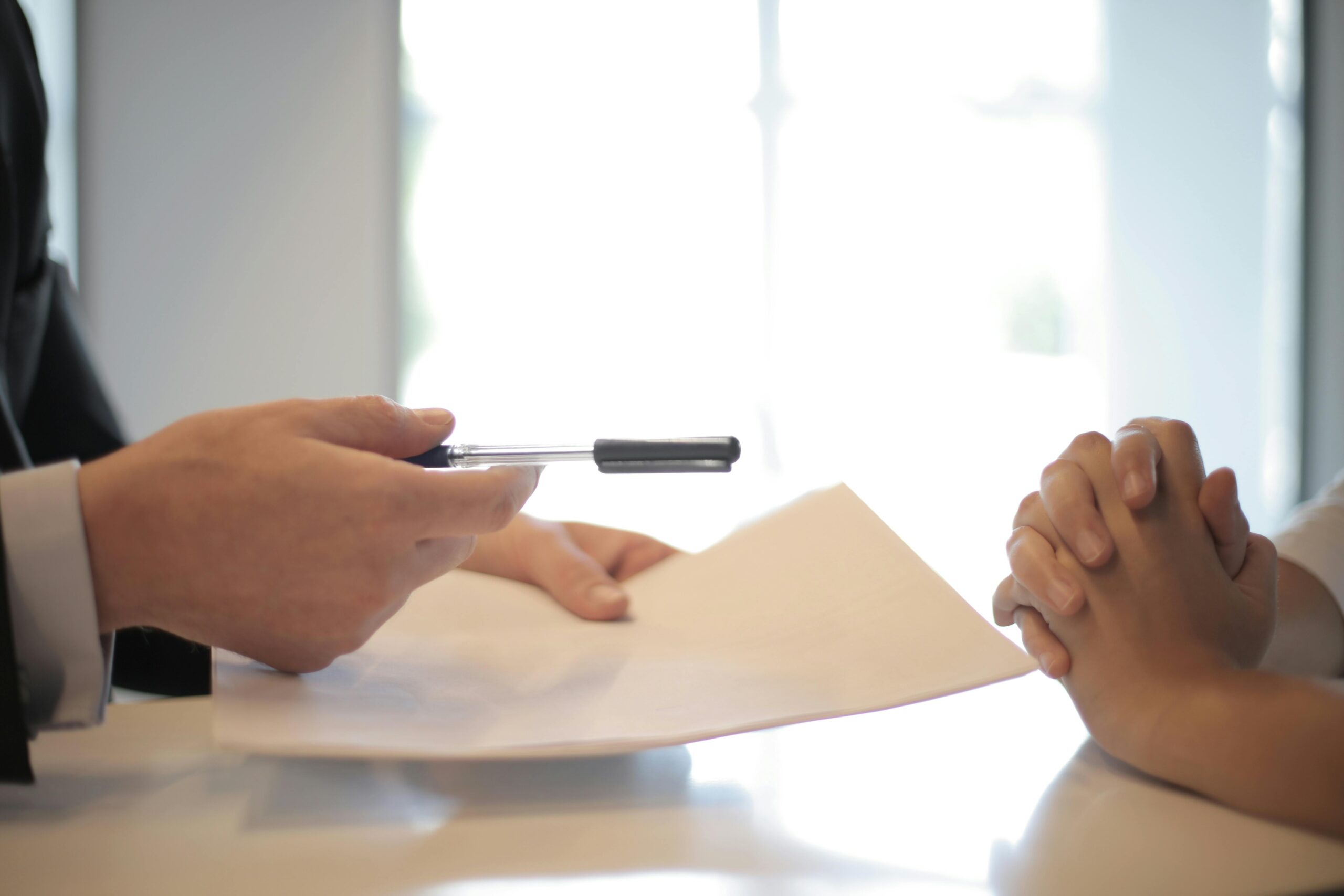 Close-up of a contract signing with hands over documents. Professional business interaction. Collateral assignment of life insurance