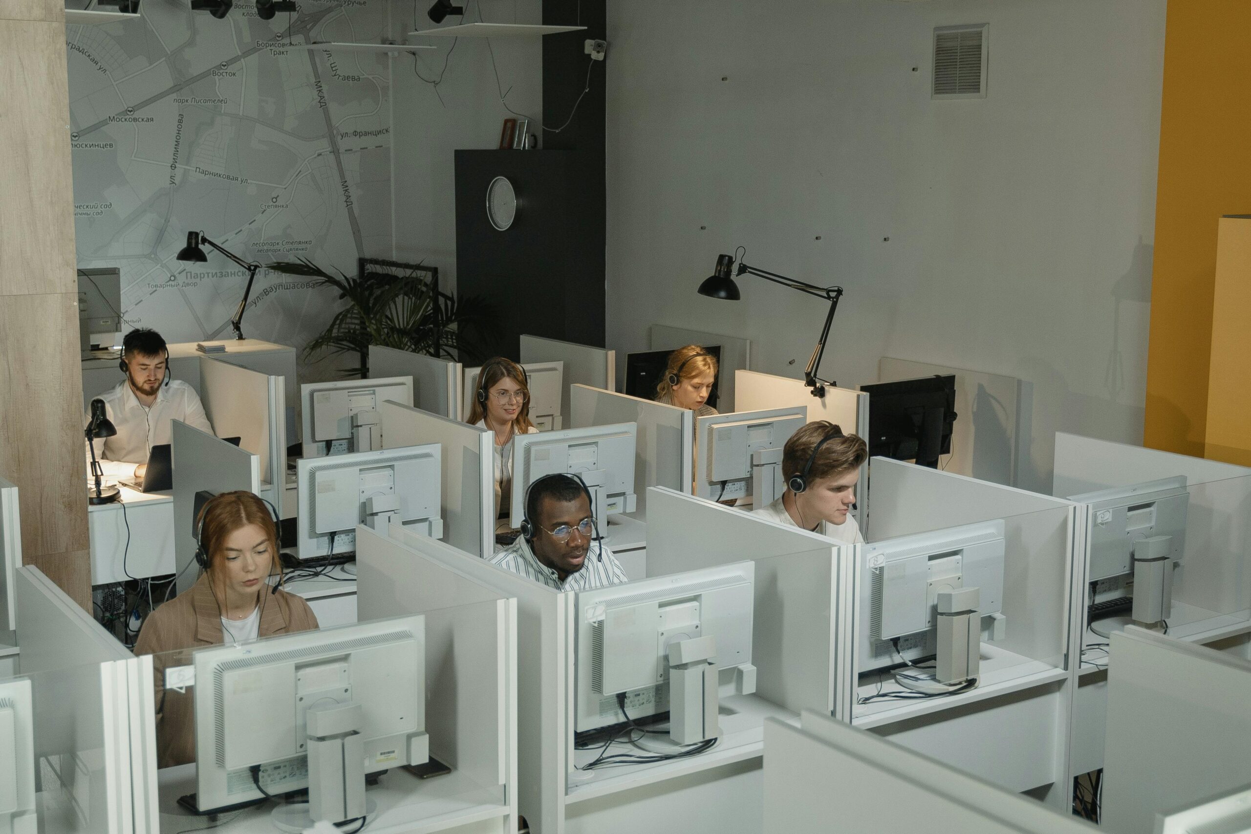 A diverse team of debt collection staff working in a modern call center environment.