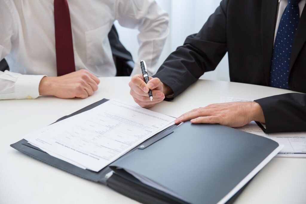 Two professionals signing a contract for debt settlement services